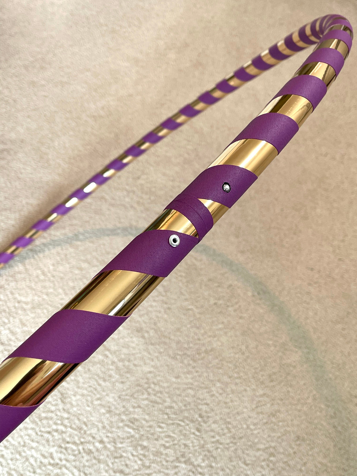 Purple hula hoop with gold reflective tape and small grommet detail on the strap