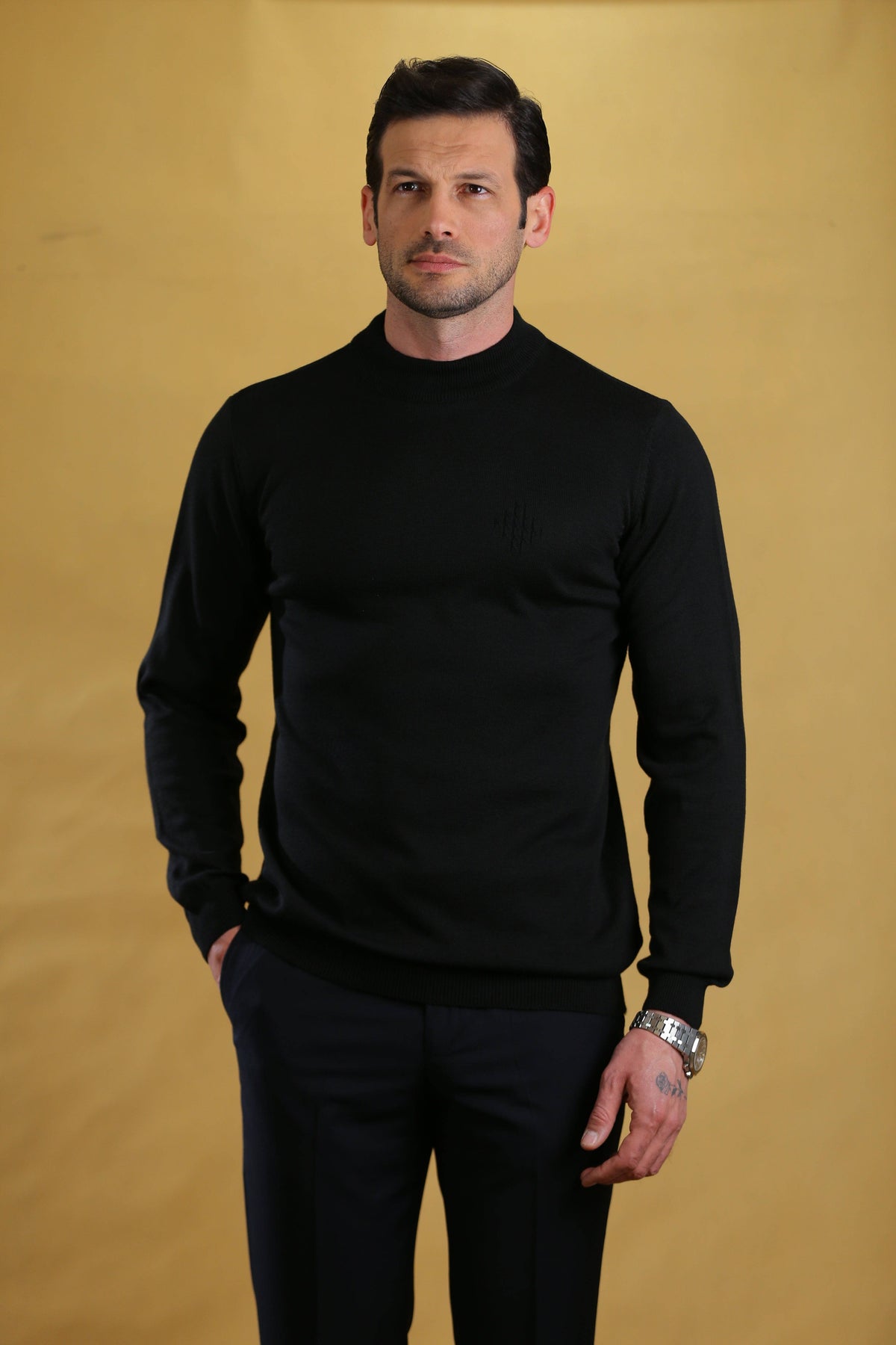 Black crewneck knit sweater with long sleeves and ribbed cuffs and hem