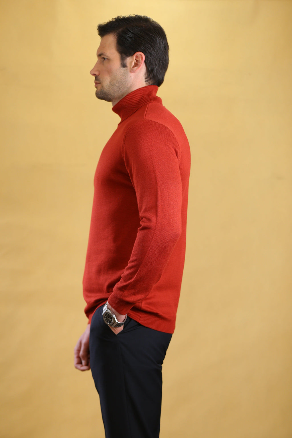 Men's red turtleneck sweater, side profile with long sleeves and ribbed cuffs.