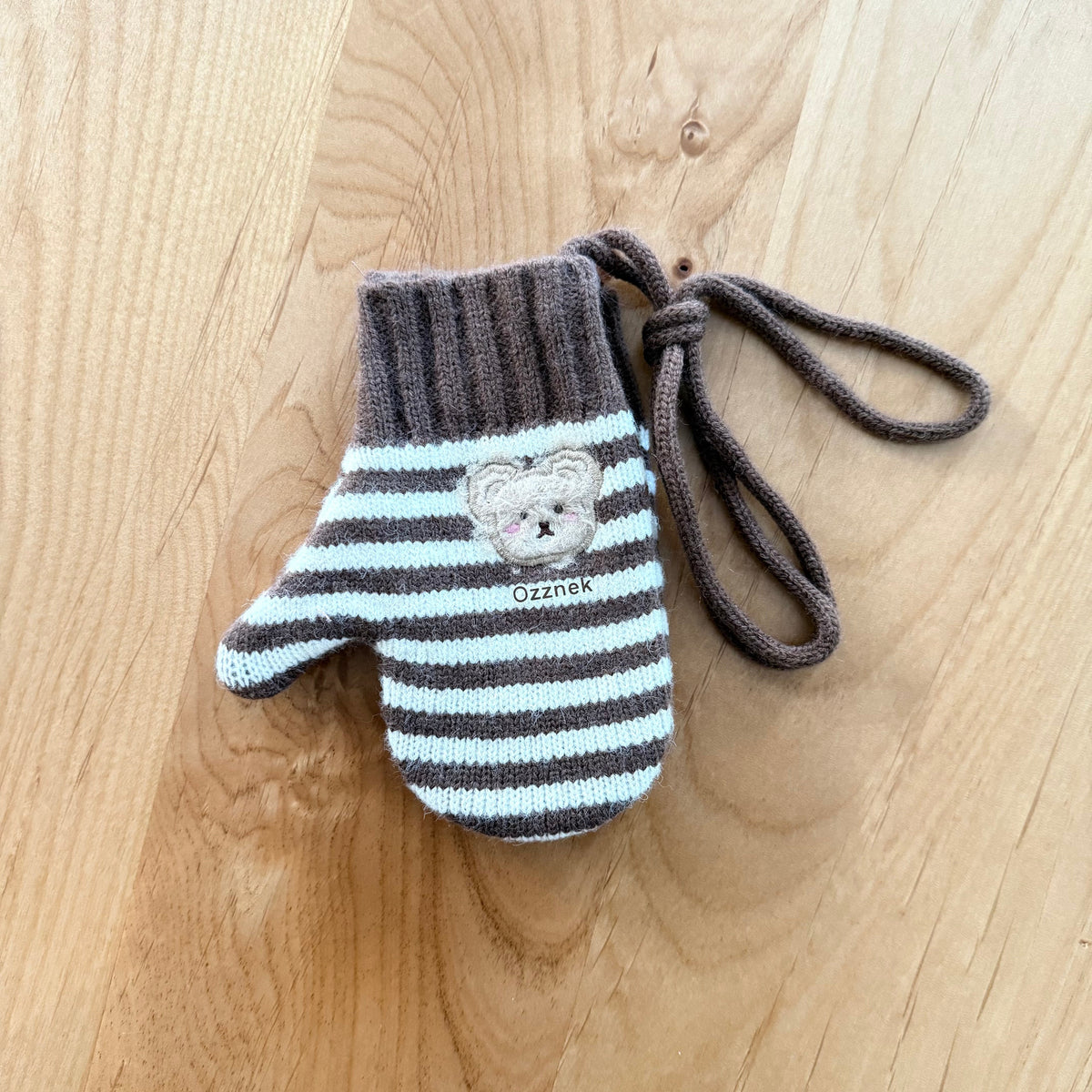 Kids winter mittens with dark gray striped knit, bear emblem, and bow tie strings