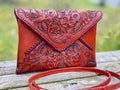 Hand-tooled leather crossbody clutch bag, red leather with carved floral front and strap