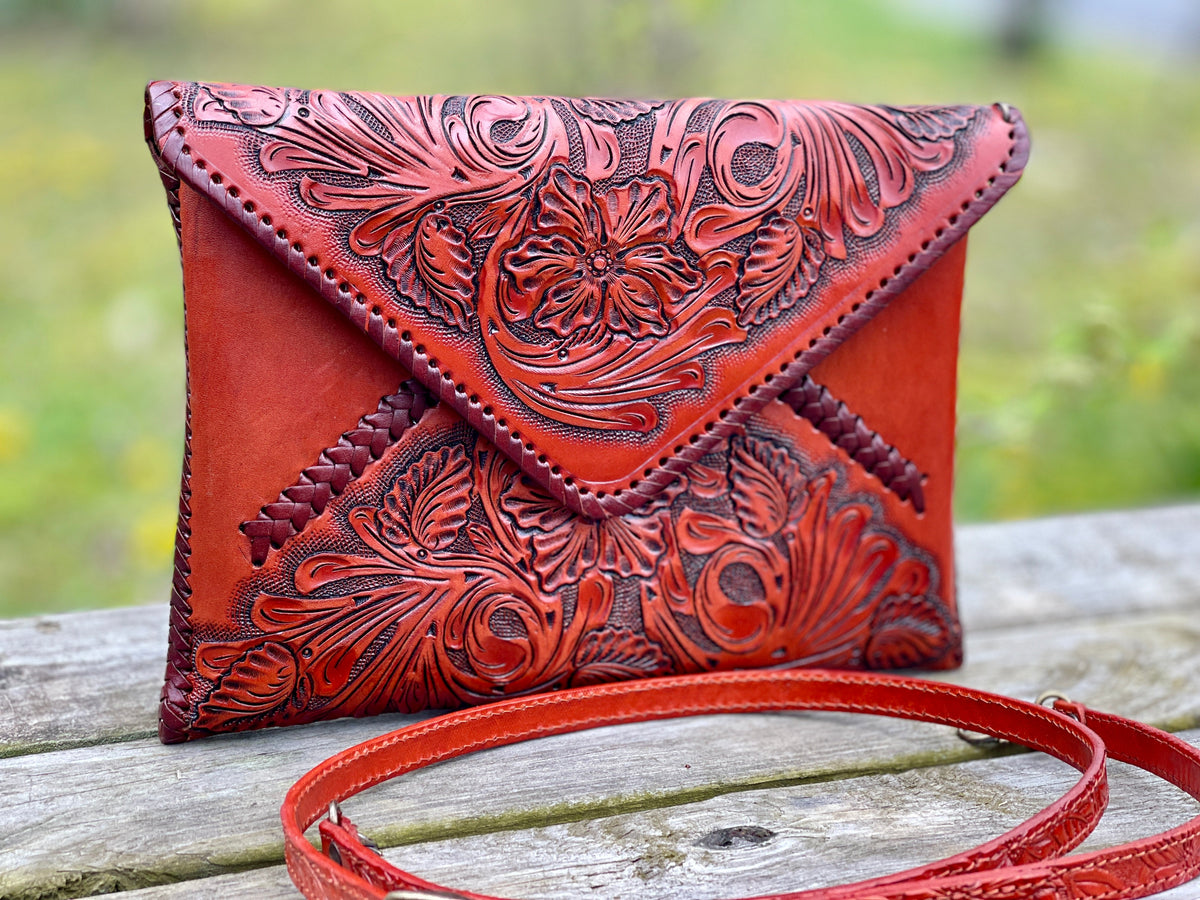 Hand-tooled leather crossbody clutch bag, red leather with carved floral front and strap
