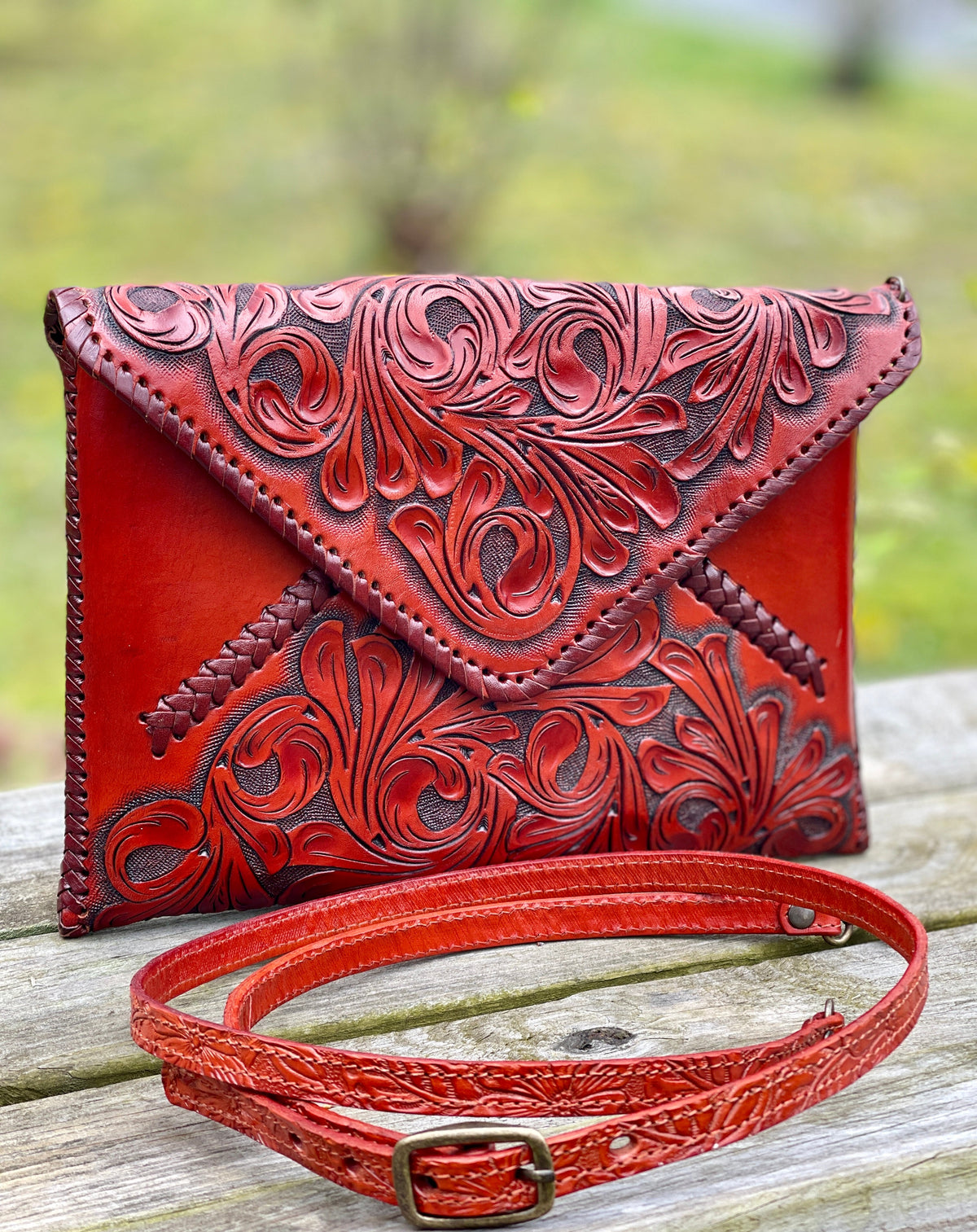 Hand-tooled leather crossbody clutch bag, deep red with embossed floral detailing