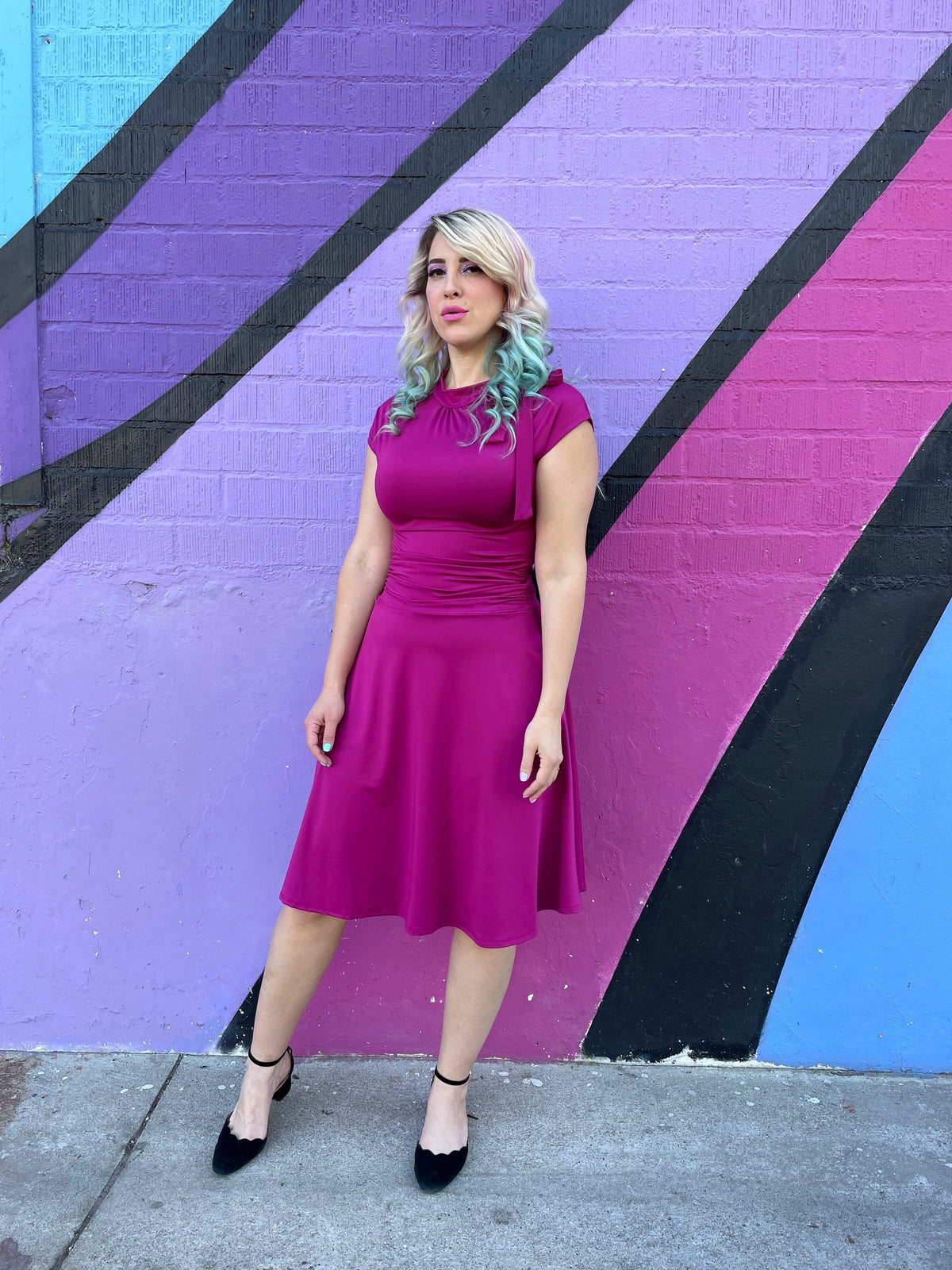 Magenta midi fitted dress with ruched waist, tied shoulder bow, and swing skirt