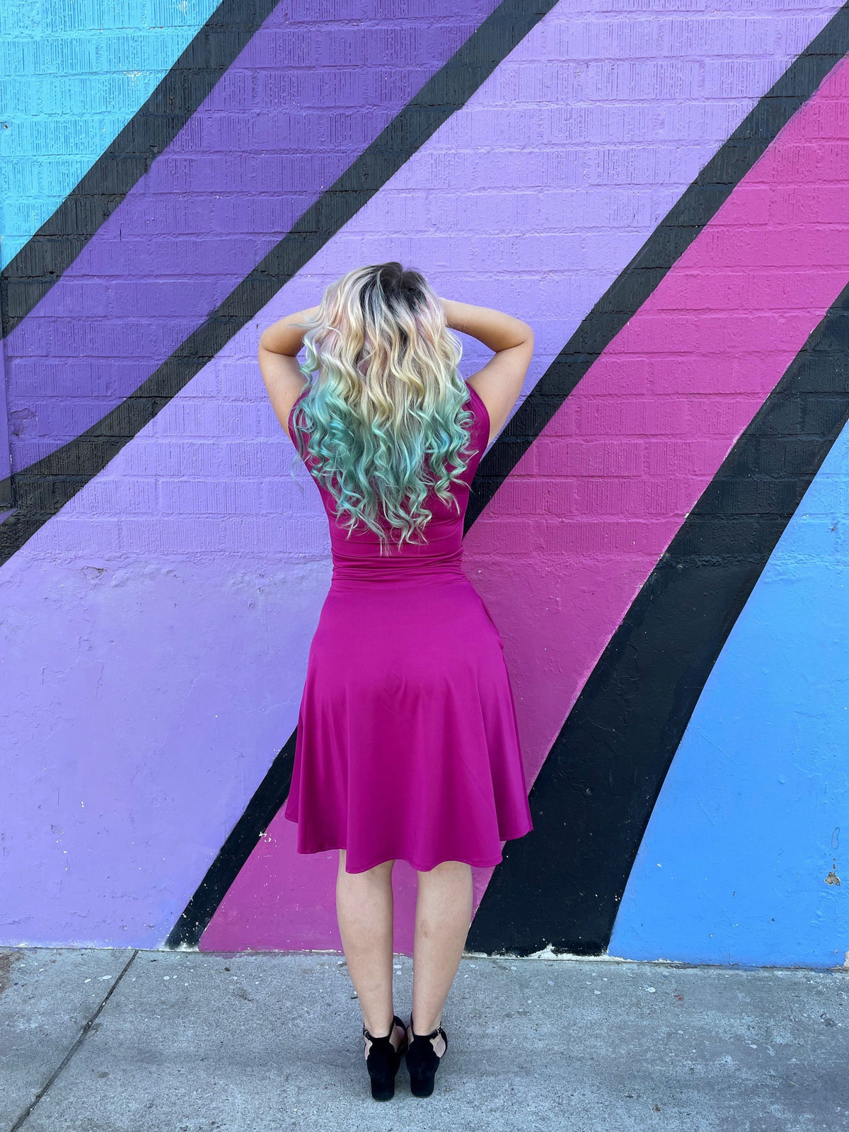 Magenta midi dress with ruched waist and tied shoulder bow, flared back view