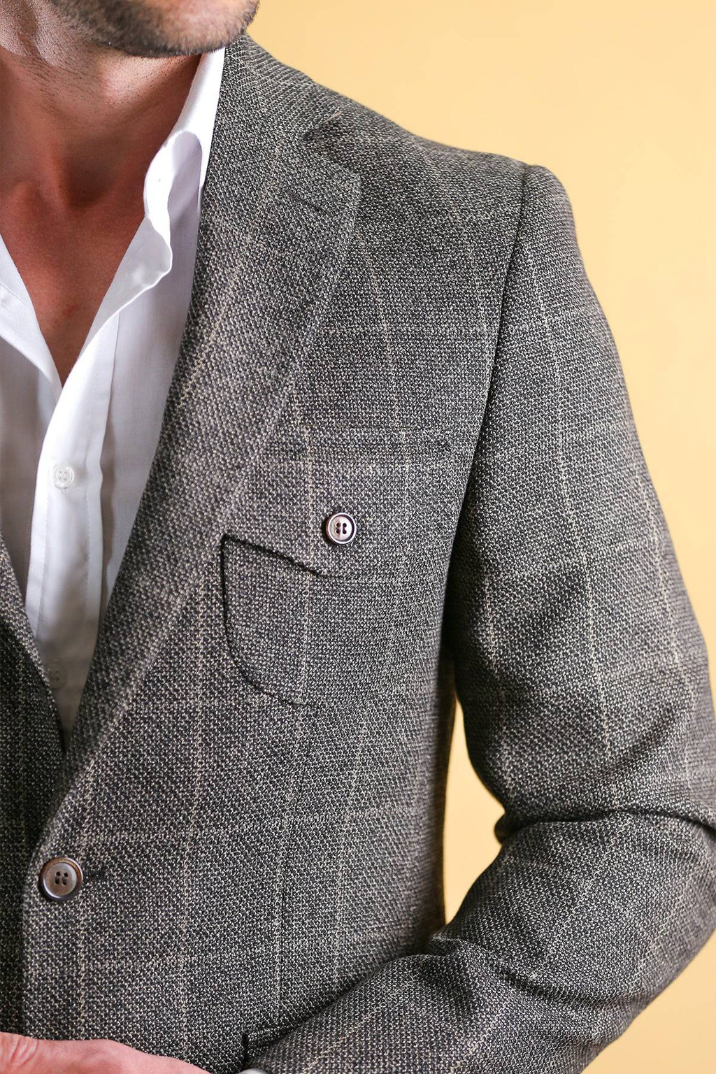 Men's vintage blazer shoulder and chest detail in dark gray check texture, flap pocket.