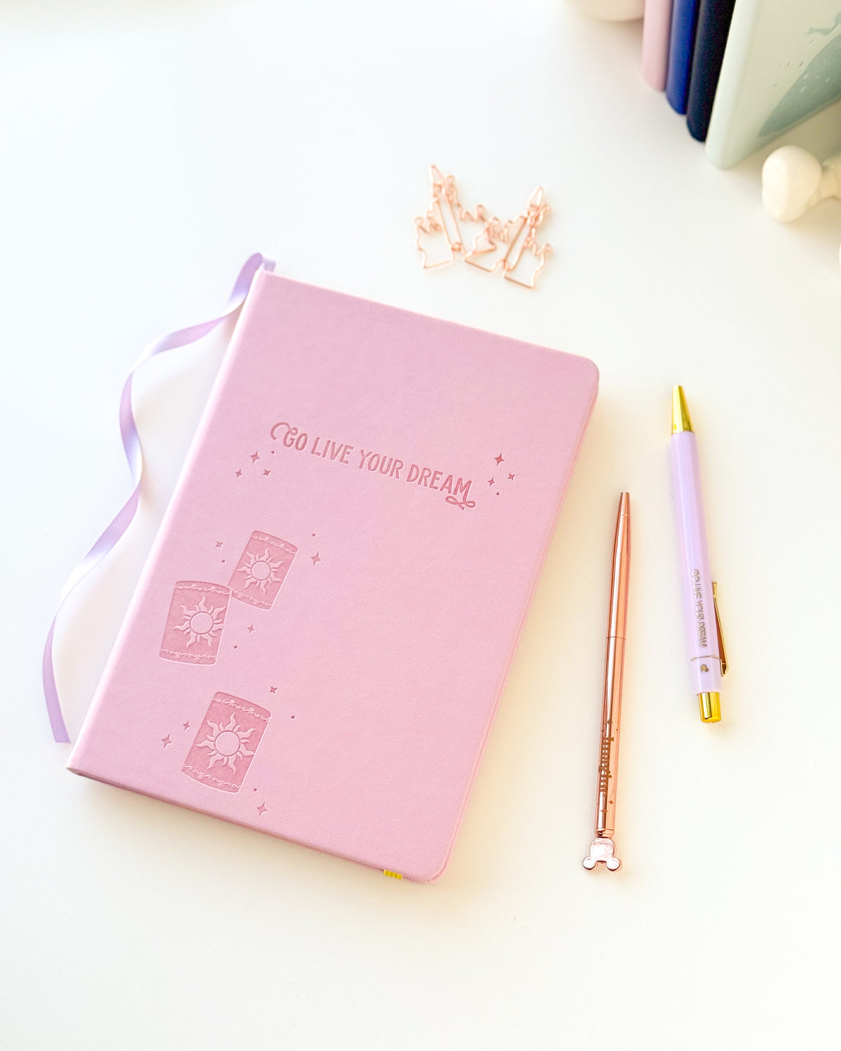 Pink notebook with embossed dream motif and lavender ribbon, yellow elastic strap