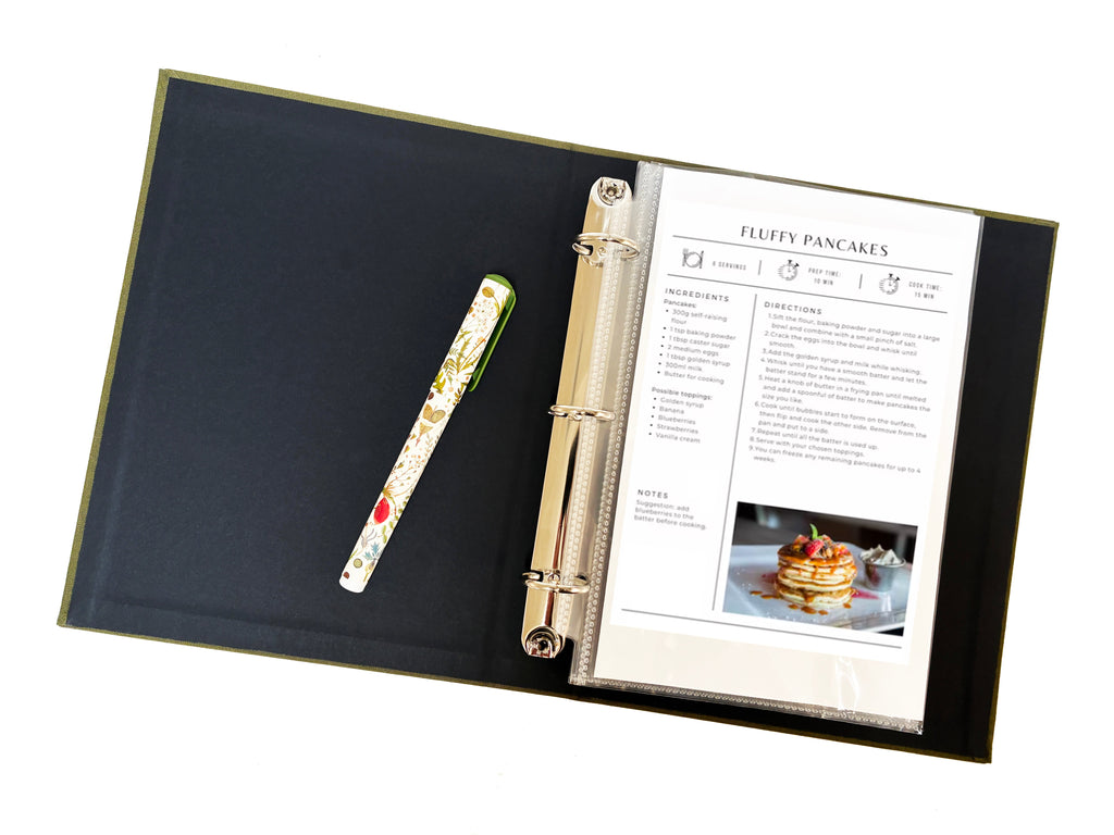 Olive green linen 3-ring binder open with documents and three rings visible