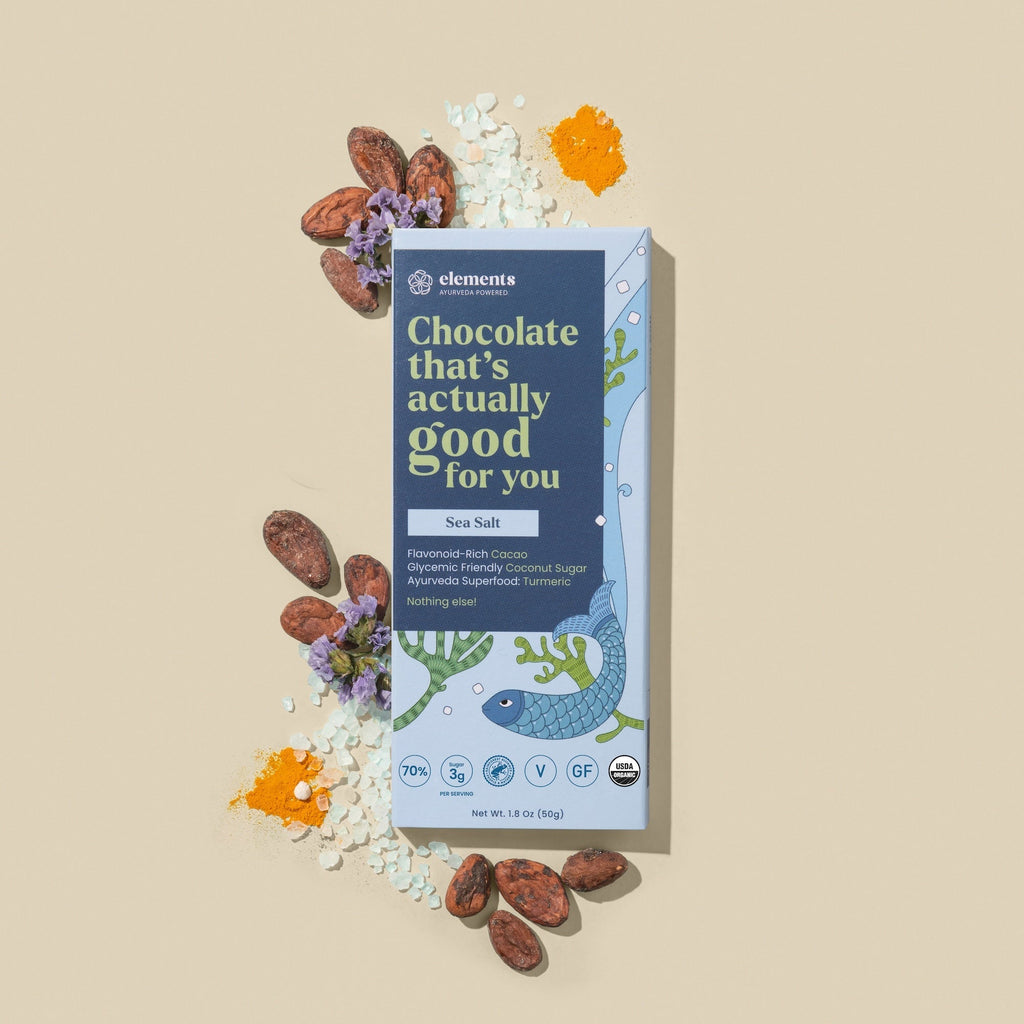 Sea salt chocolate bar in blue packaging, shown with cocoa pieces and sea salt crystals.