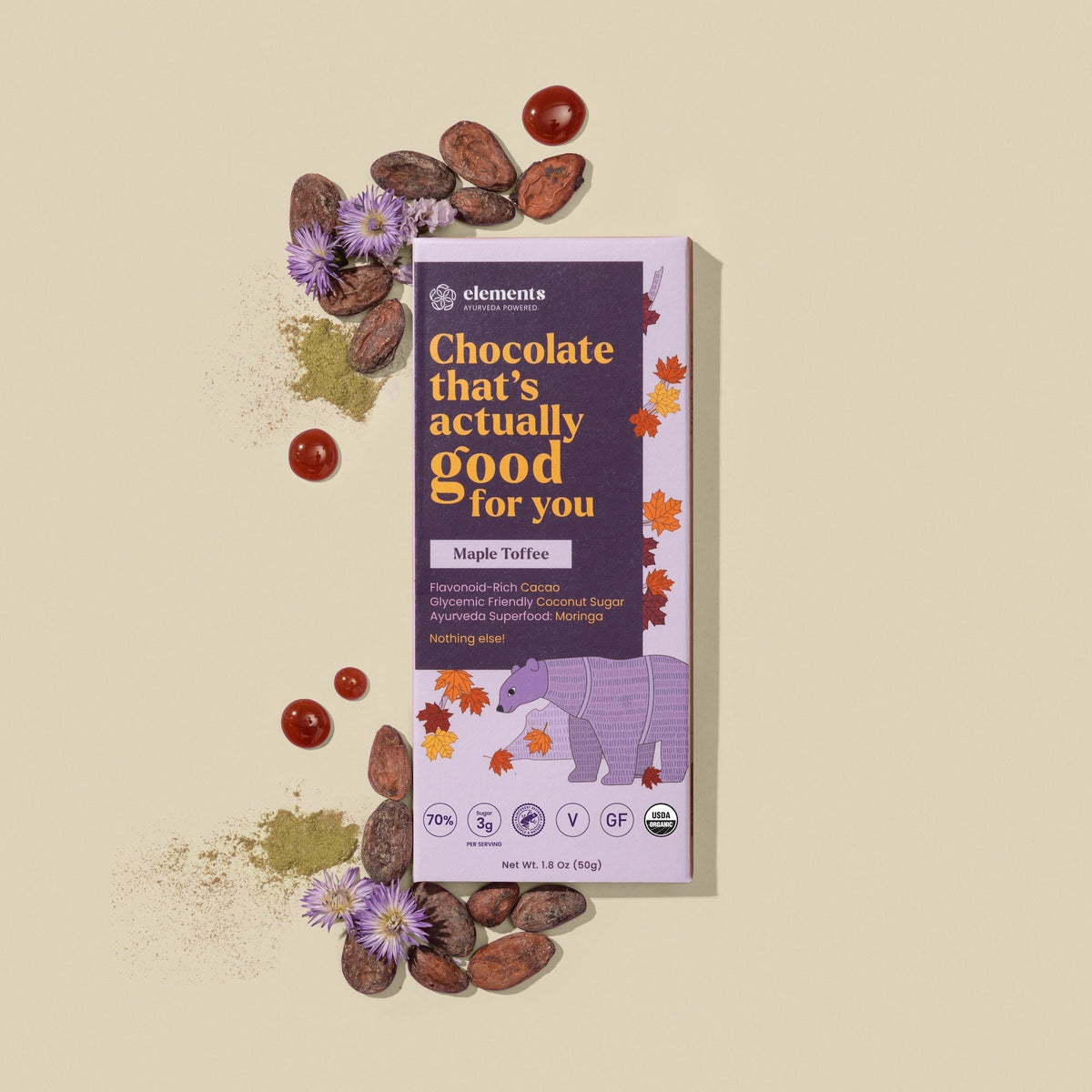 Maple toffee chocolate bar box with scattered cacao pieces and dried leaves