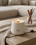 Cream cylindrical scented candle with flame, labeled Cinnamon Vanilla