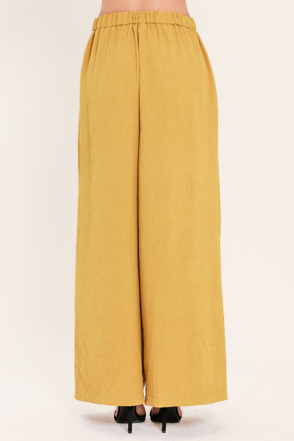 Mustard woven wide-leg pants shown from back with elastic waistband