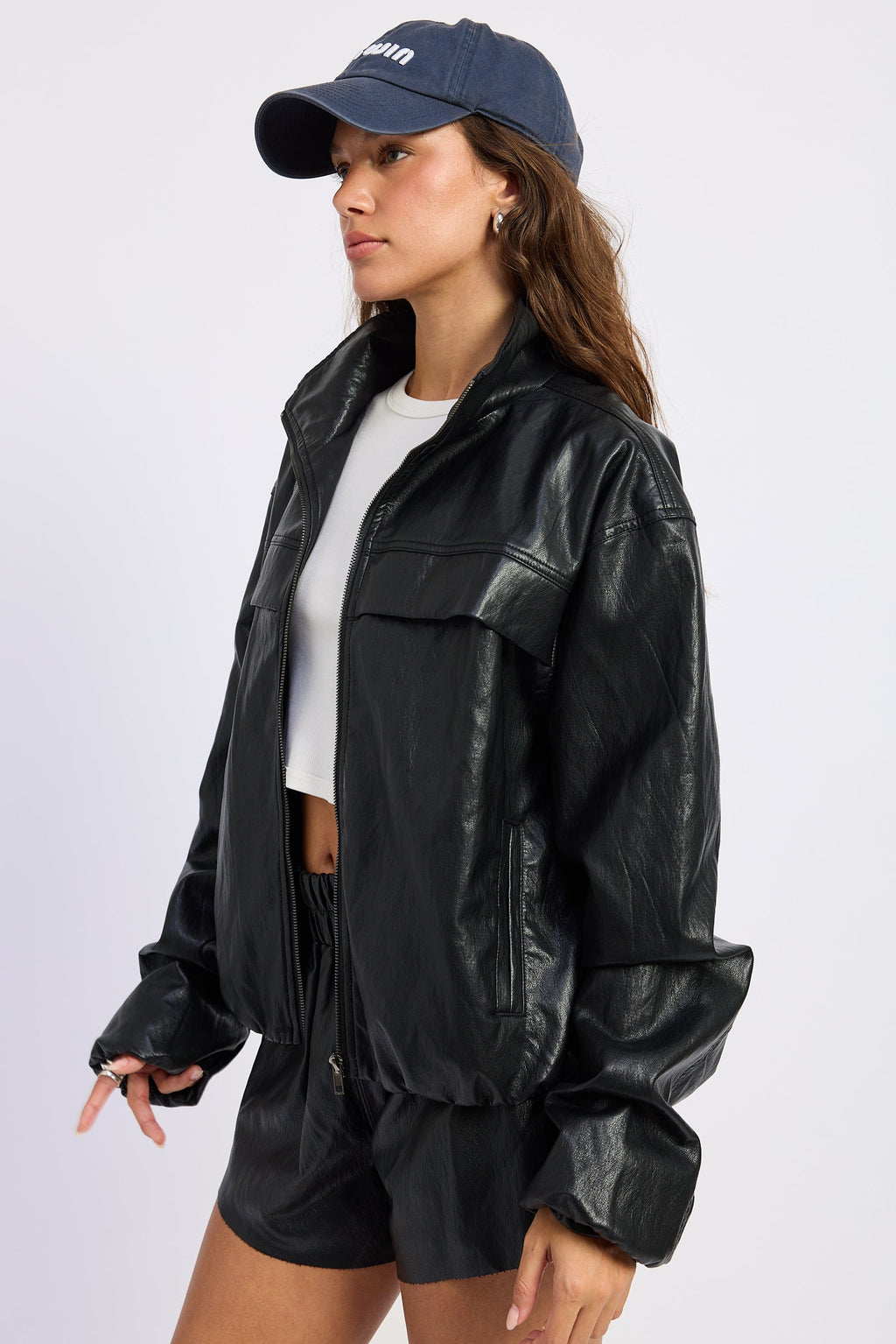 Black leather-look jacket with flap pockets and long sleeves, side profile