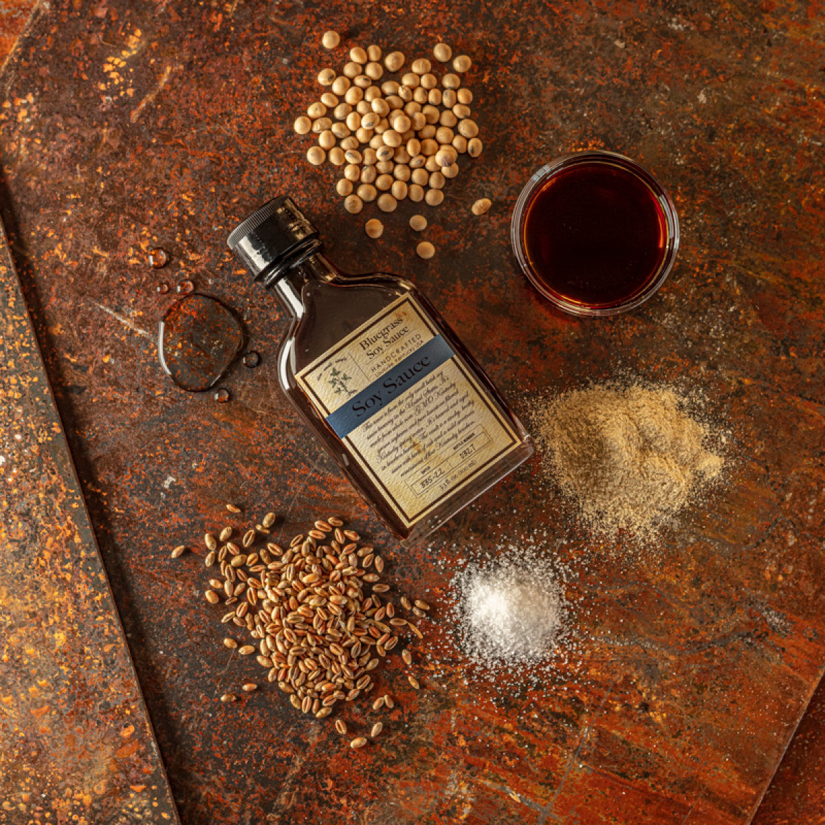 Soy sauce bottle with soybeans and seasoning beside a small bowl