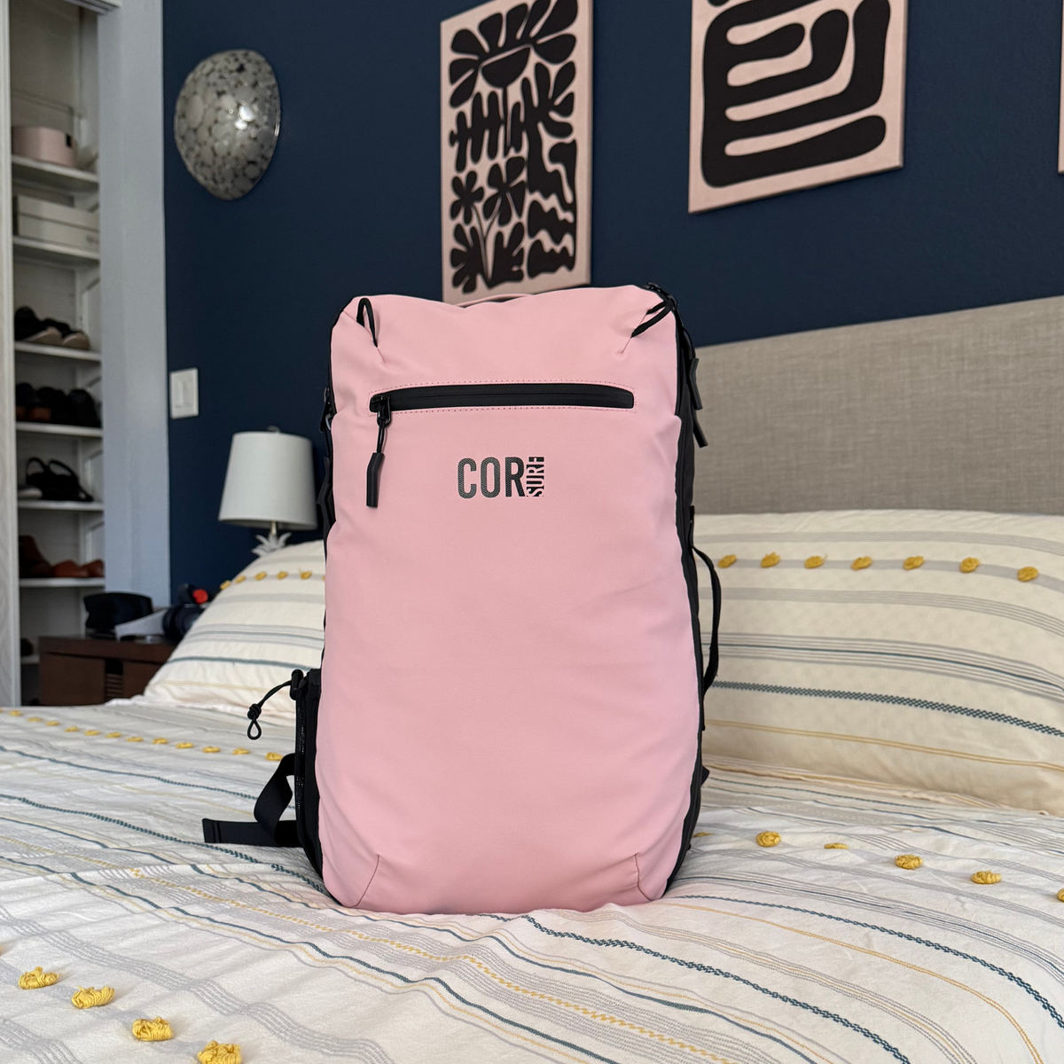 28L travel backpack in light pink with top handle and zip front logo pocket
