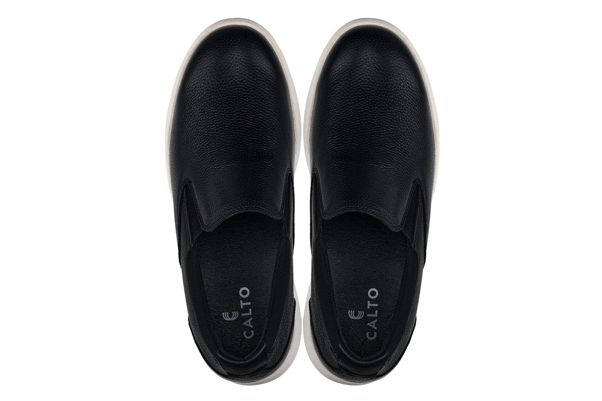 Pair of black leather loafers with cushioned insoles, toe openings facing front