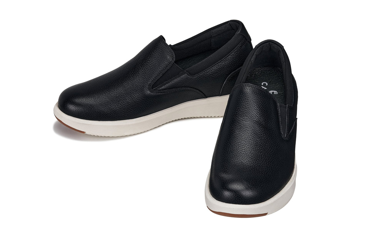 Black leather loafers with white midsoles and low-profile heel, angled side view