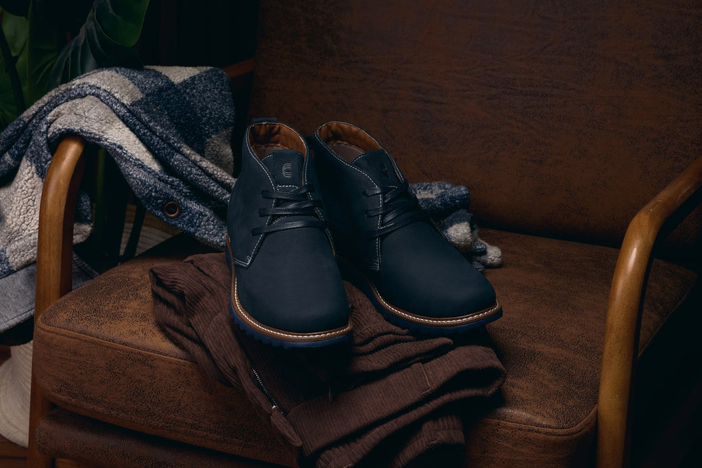 Navy nubuck chukka boots with lace-up closure and brown welt trim