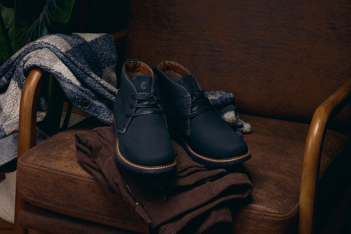 Navy nubuck chukka boots with lace-up closure and brown welt trim