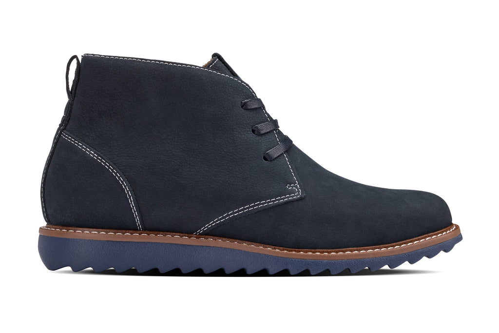 Navy nubuck chukka boot side view with lace-up laces, contrast stitching, brown sole trim