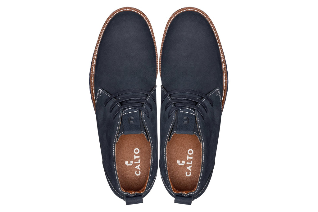 Pair of navy chukka boots with lace-up closure and CALTO branding on sock lining
