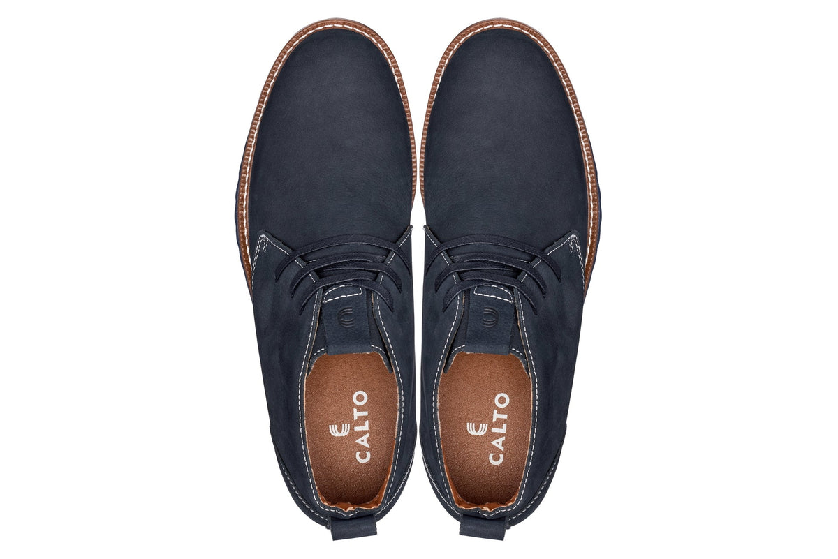 Pair of navy chukka boots with lace-up closure and CALTO branding on sock lining