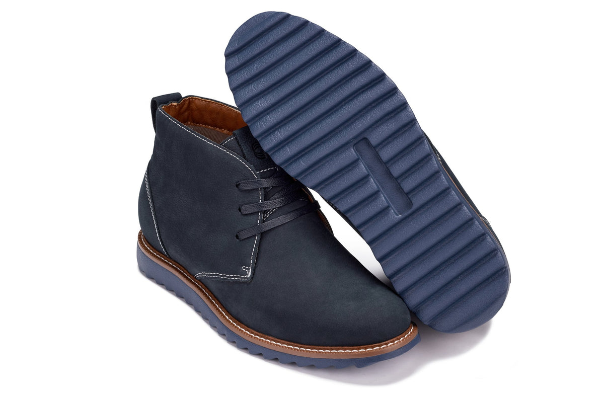 Navy chukka boots with ridged blue outsole and brown welt trim