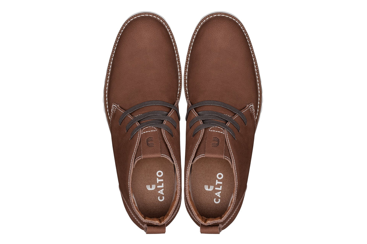 Brown nubuck chukka boots, lace-up front and stitched upper, with white outsole