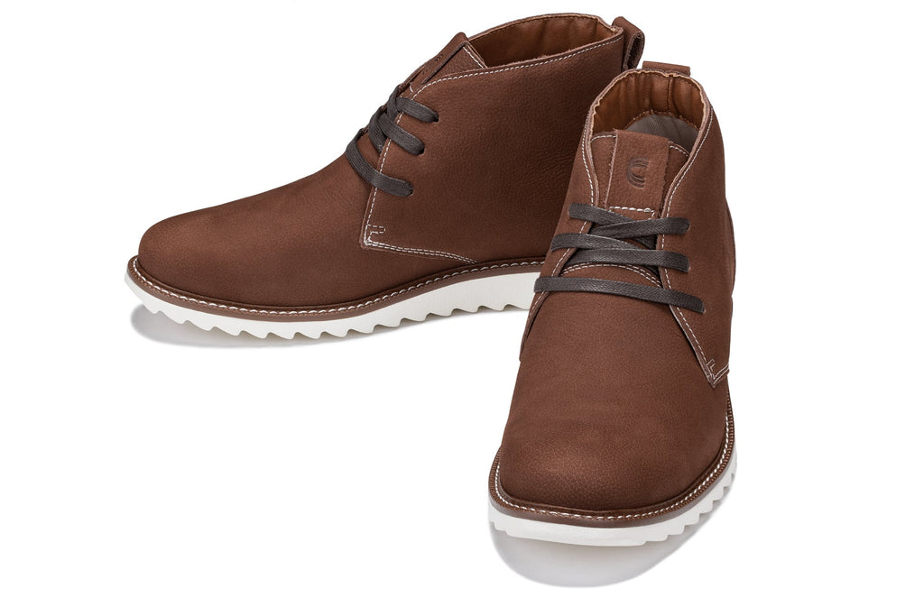 Pair of brown nubuck chukka boots with lace-up closure and white rubber outsole