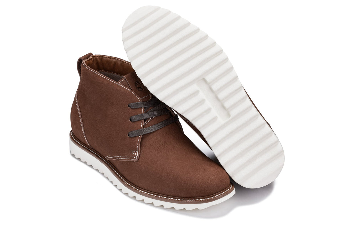 Brown chukka boots with white rubber outsole tread visible and lace-up upper