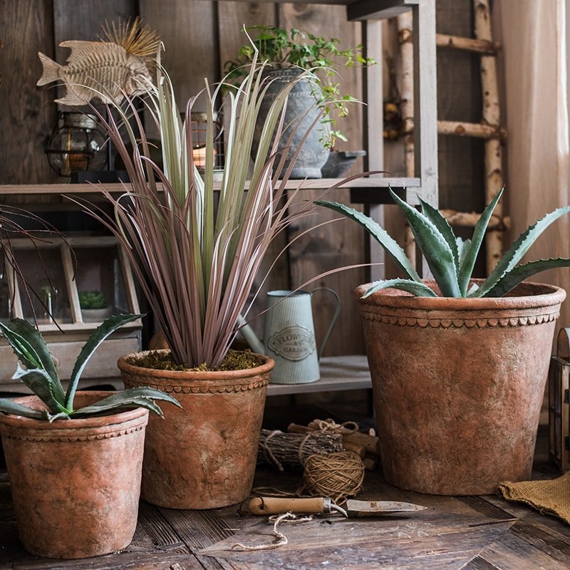 Terracotta red concrete planter pot collection with scalloped rims for plants