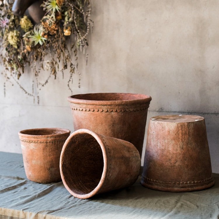 Terracotta red concrete planter pot set with one pot tipped on its side