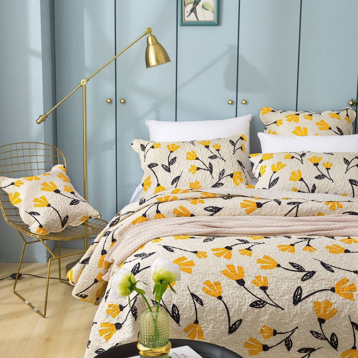 Ivory quilt set with yellow flower print and black leaves on bed
