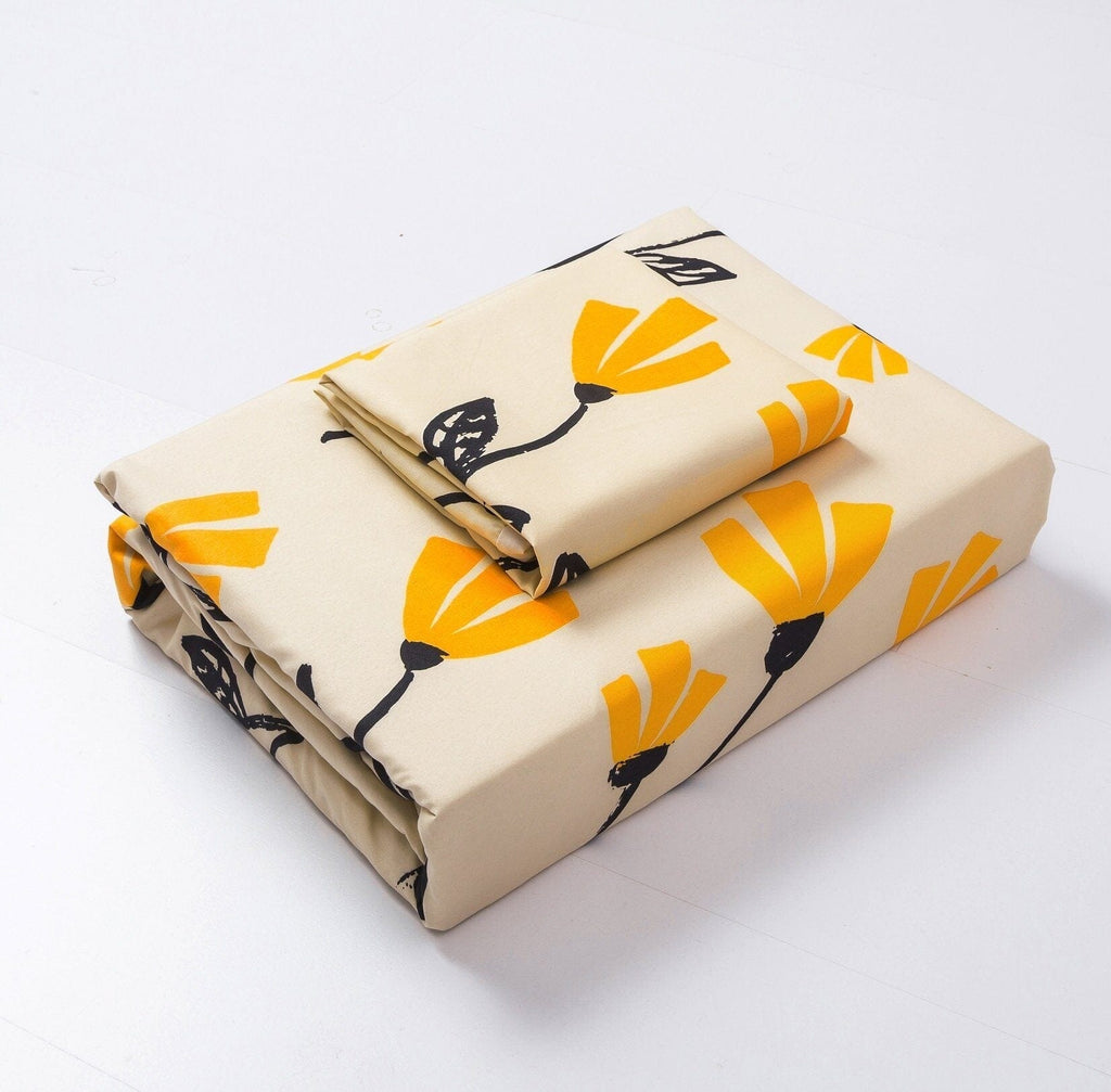 Folded duvet cover set in cream with yellow tulip and black branch print