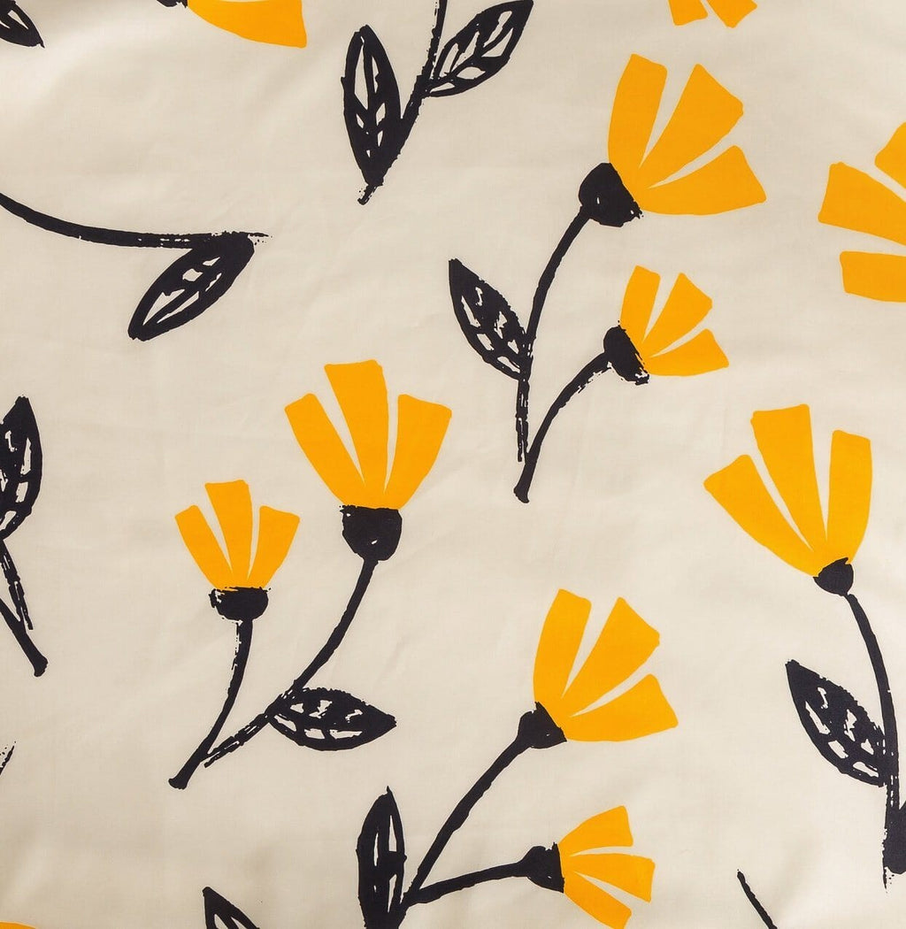 Cream duvet cover fabric with yellow flower print and black stems, close-up