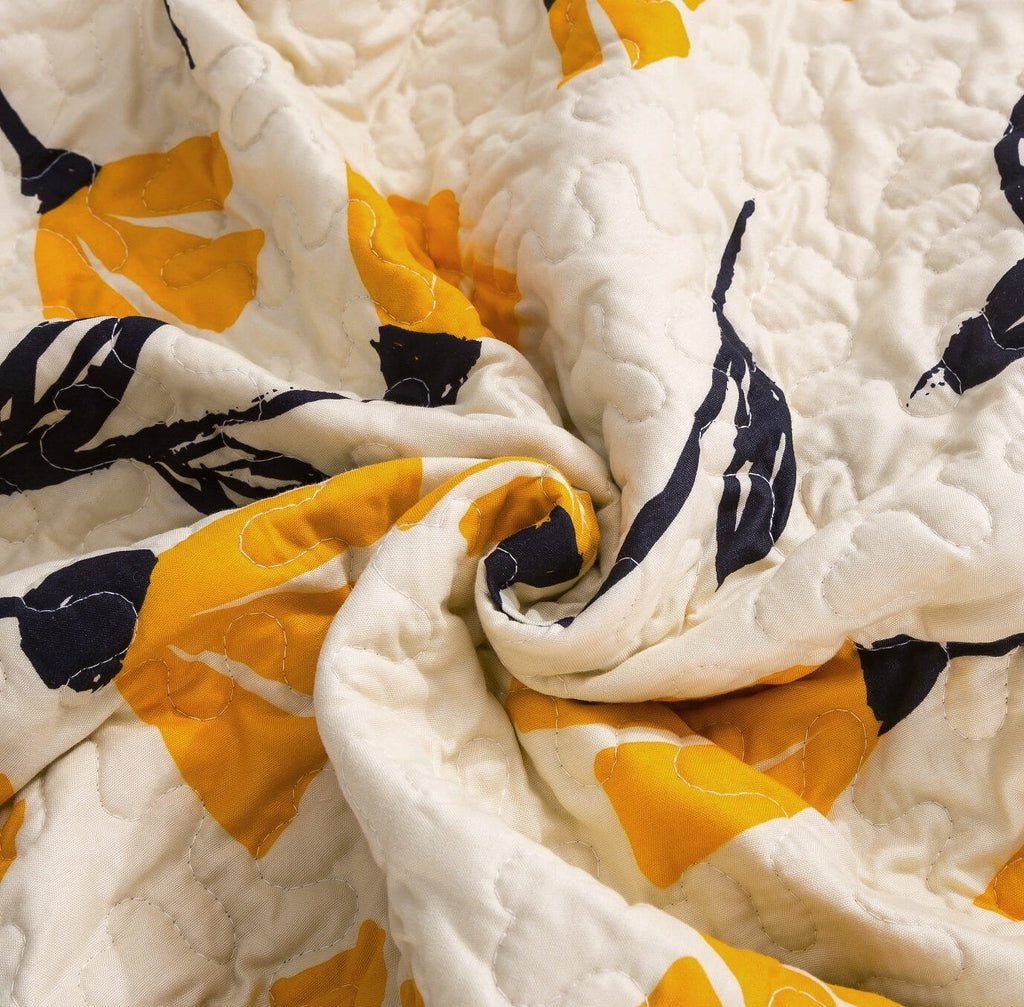 Ivory quilt fabric with quilted texture, yellow petal shapes and black leaf print