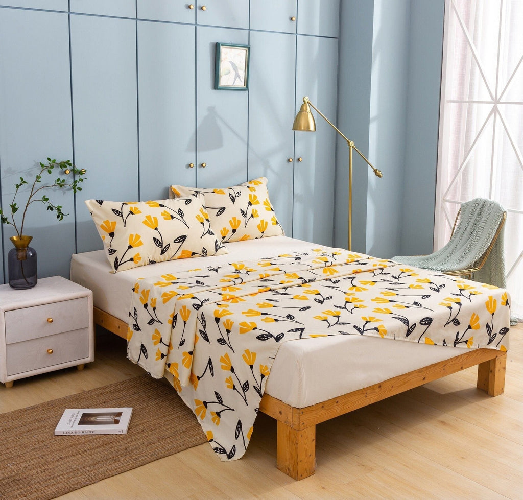Ivory floral bedding with yellow flower and leaf print, pillow shams and comforter on bed