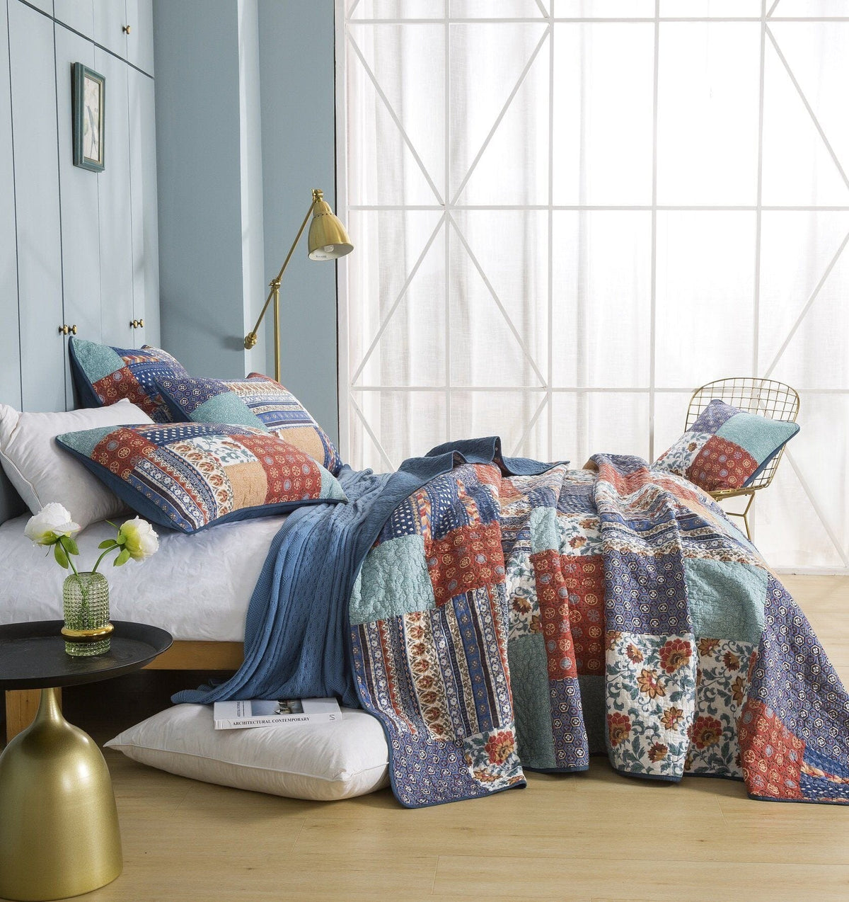 Quilted bedspread with blue, rust red, cream, and floral patchwork panels