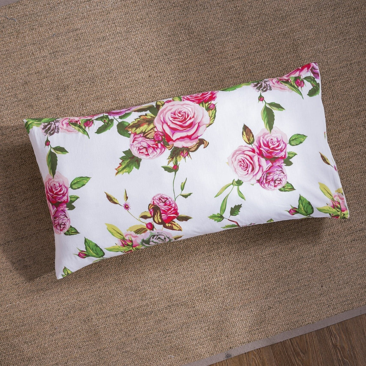 Floral pillowcase with pink roses and green leaves on white background