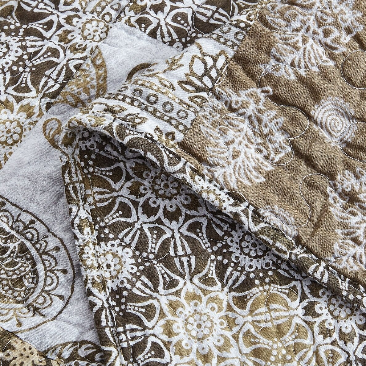 Olive-brown and white comforter with paisley floral patchwork and quilted stitching
