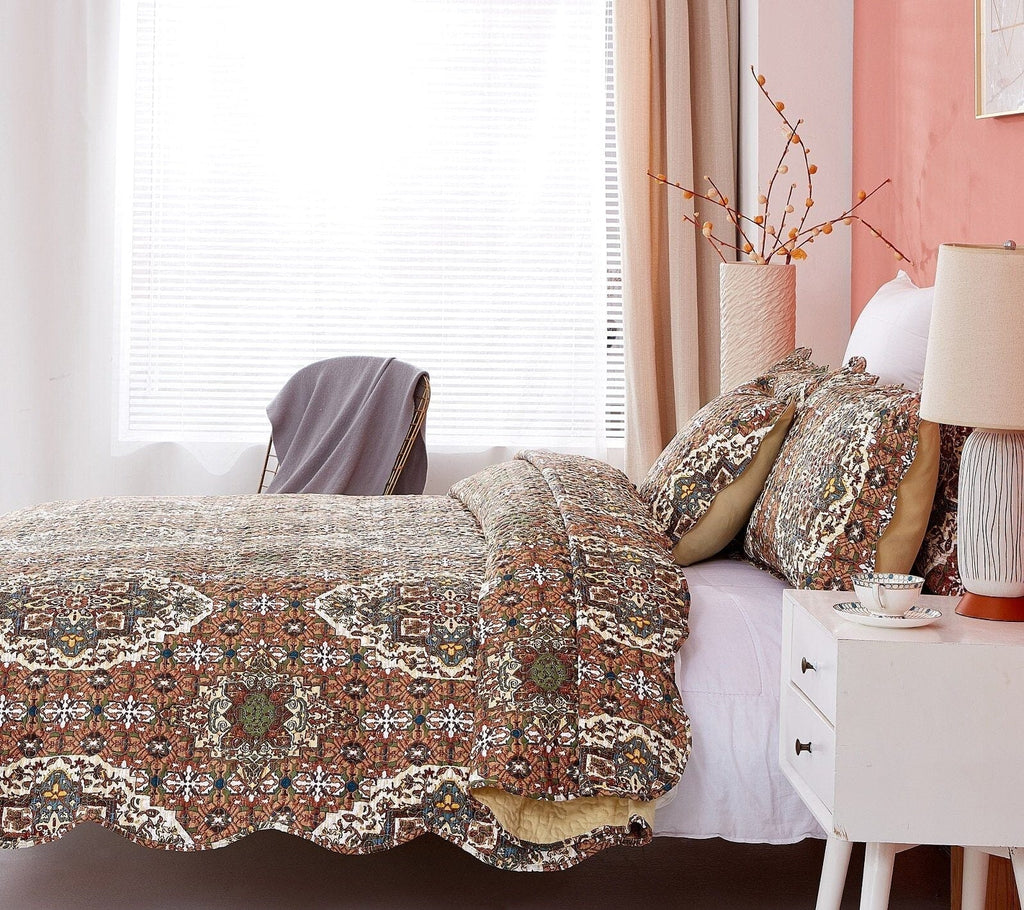 Quilted bedspread with intricate folk medallion motif and scalloped trim on coordinated shams