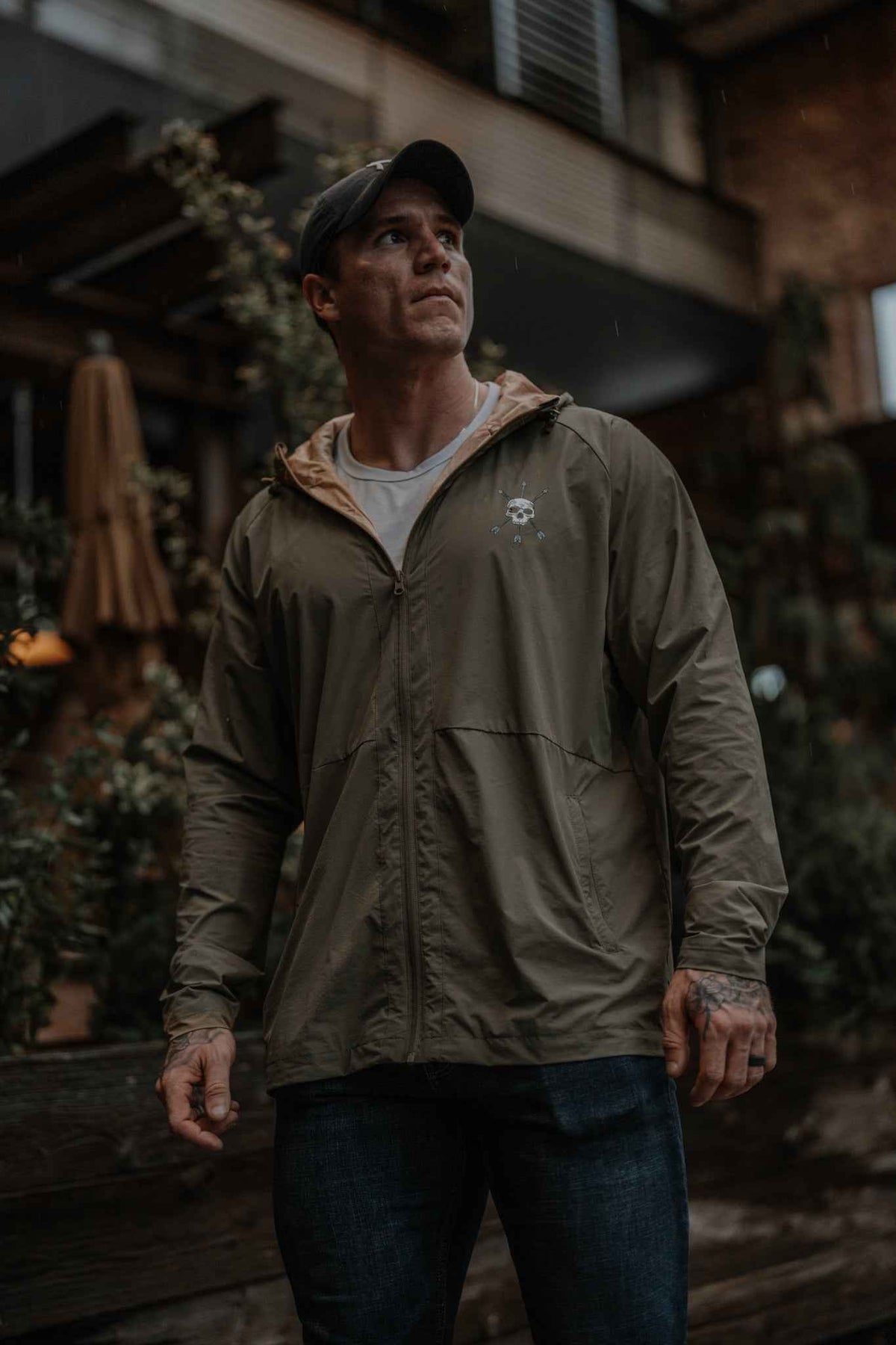 Men's olive hooded jacket on model, front view with full-zip and chest logo