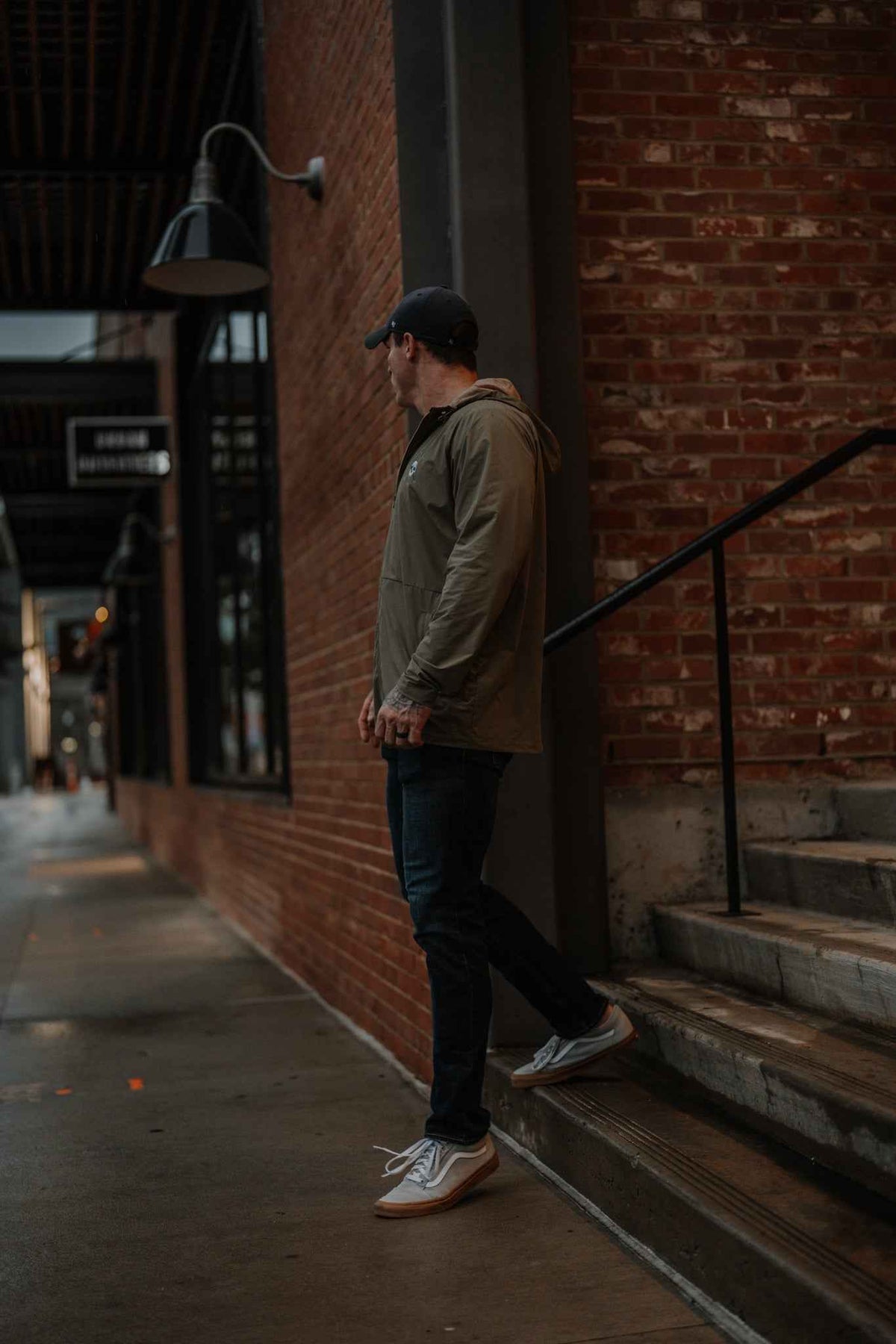 Men's olive hooded jacket on model, side profile with full-zip front