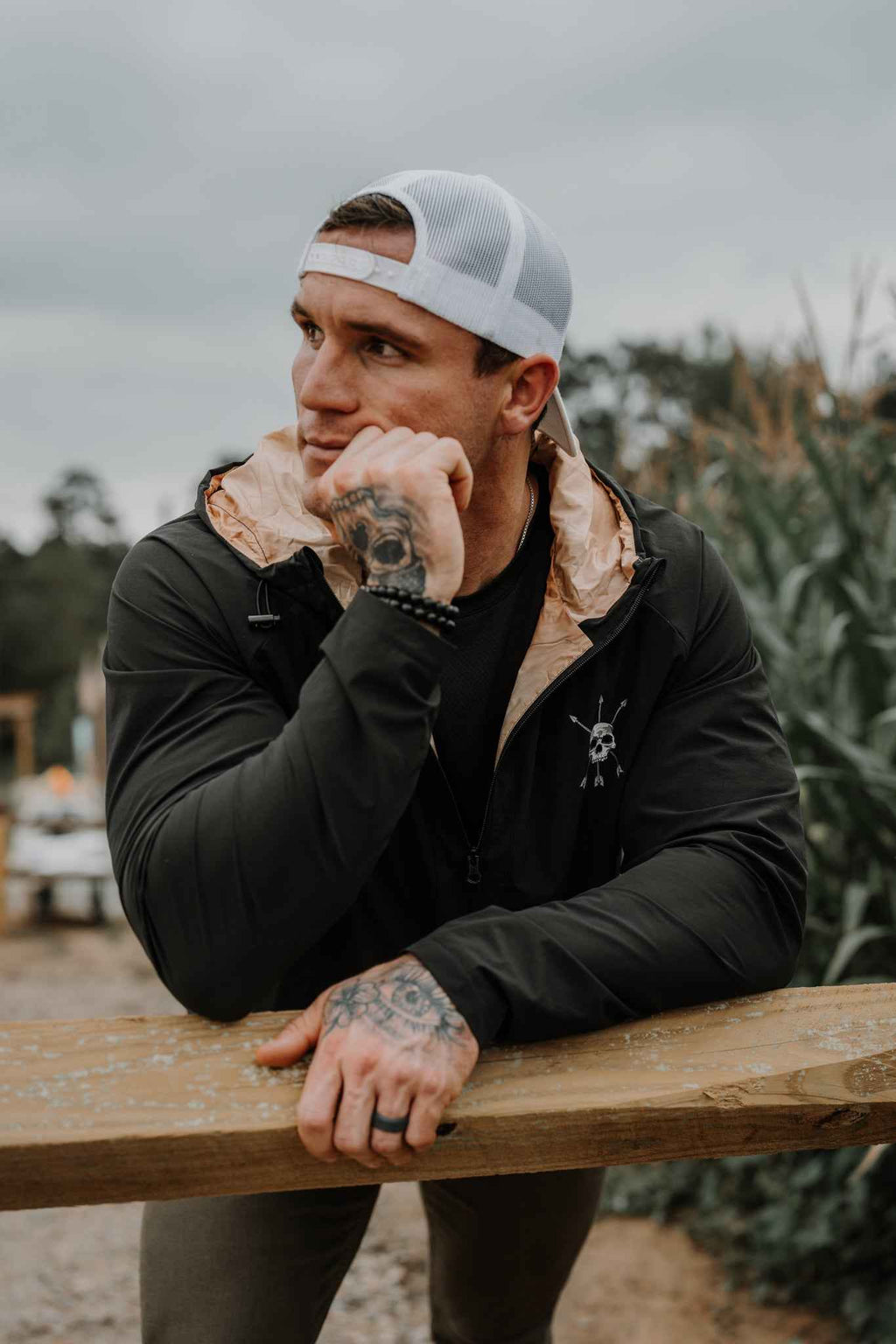 Man wearing black hooded jacket with chest skull logo
