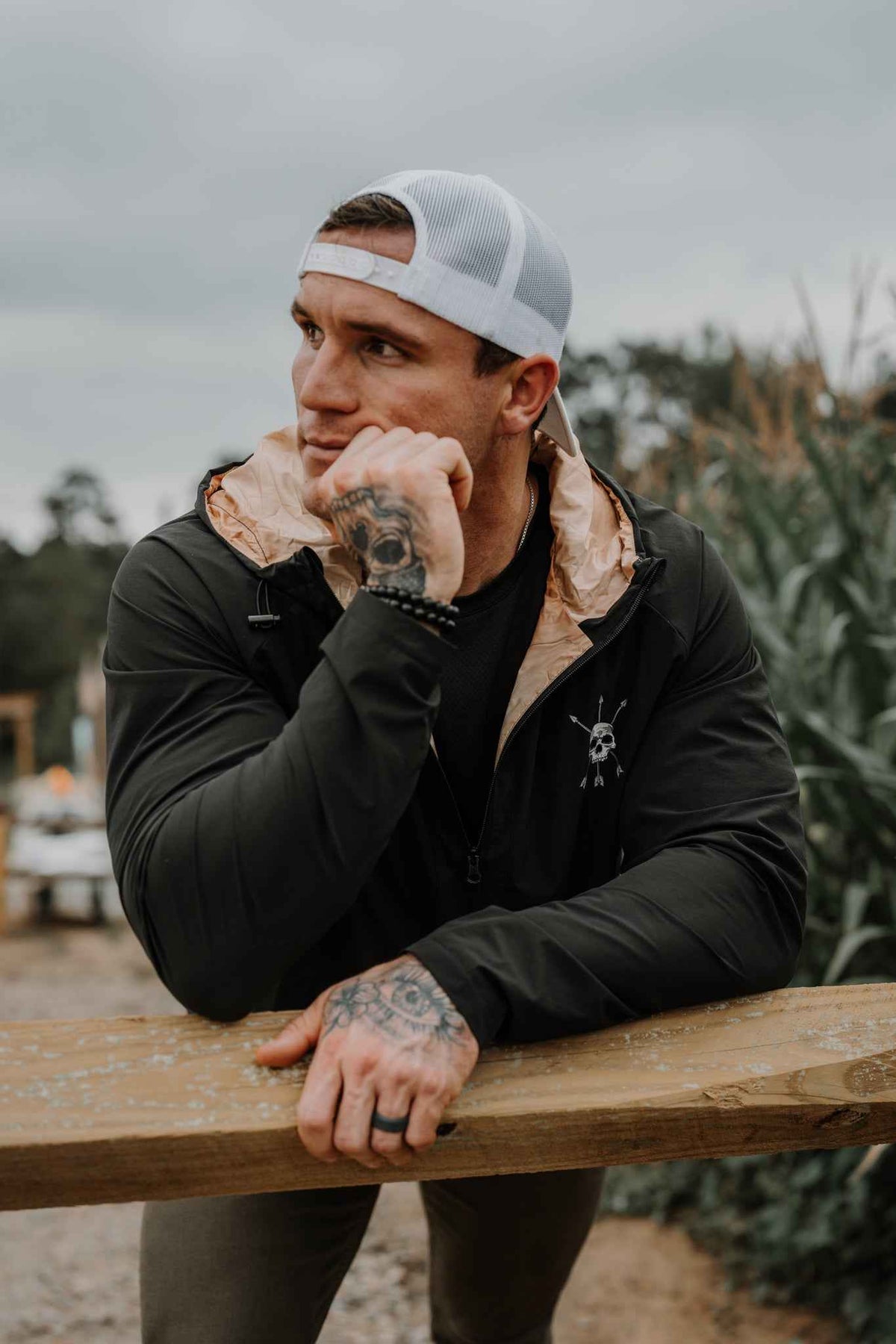 Man wearing black hooded jacket with chest skull logo