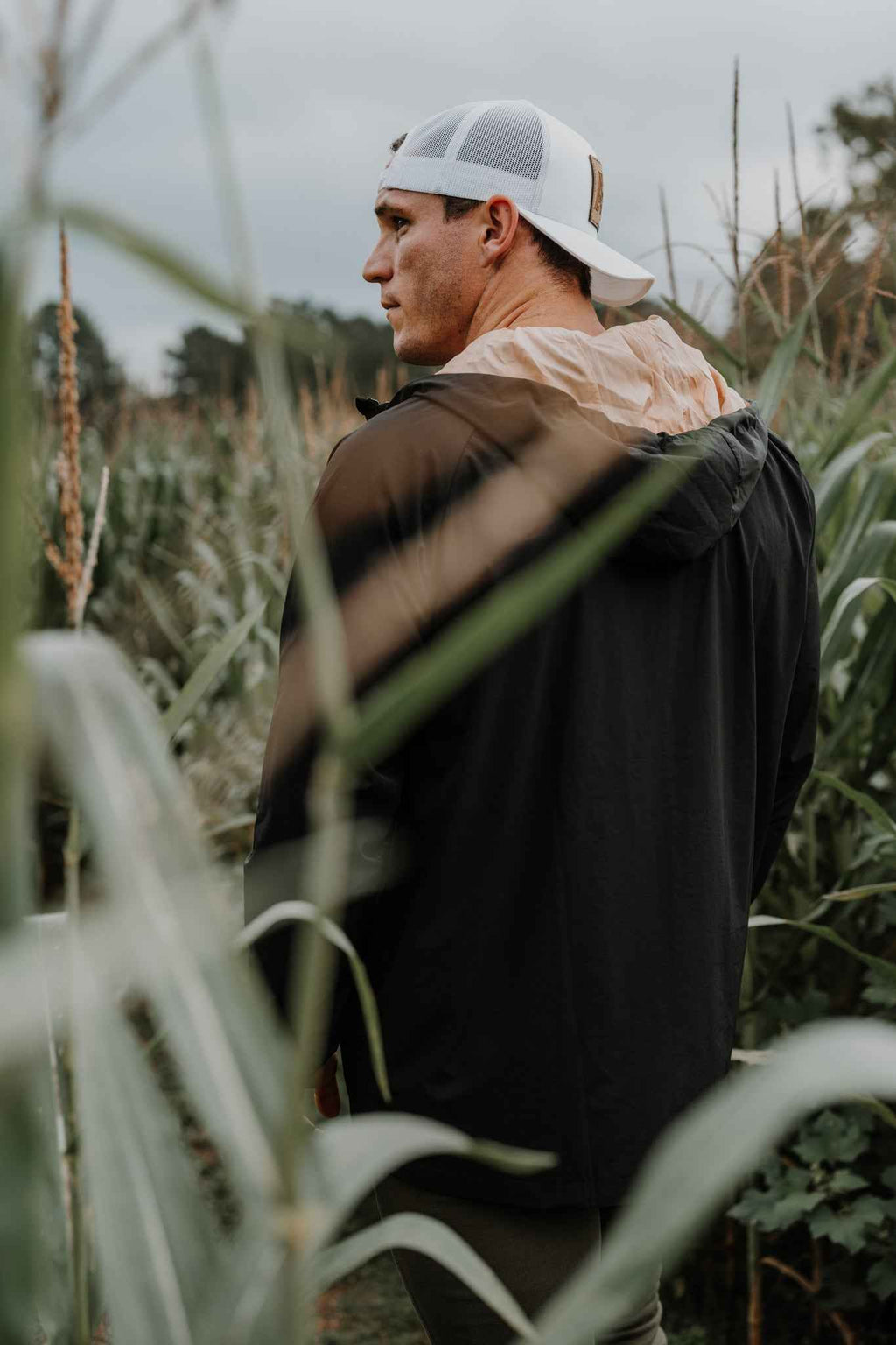 Man wearing black hooded jacket; back and hood shape visible