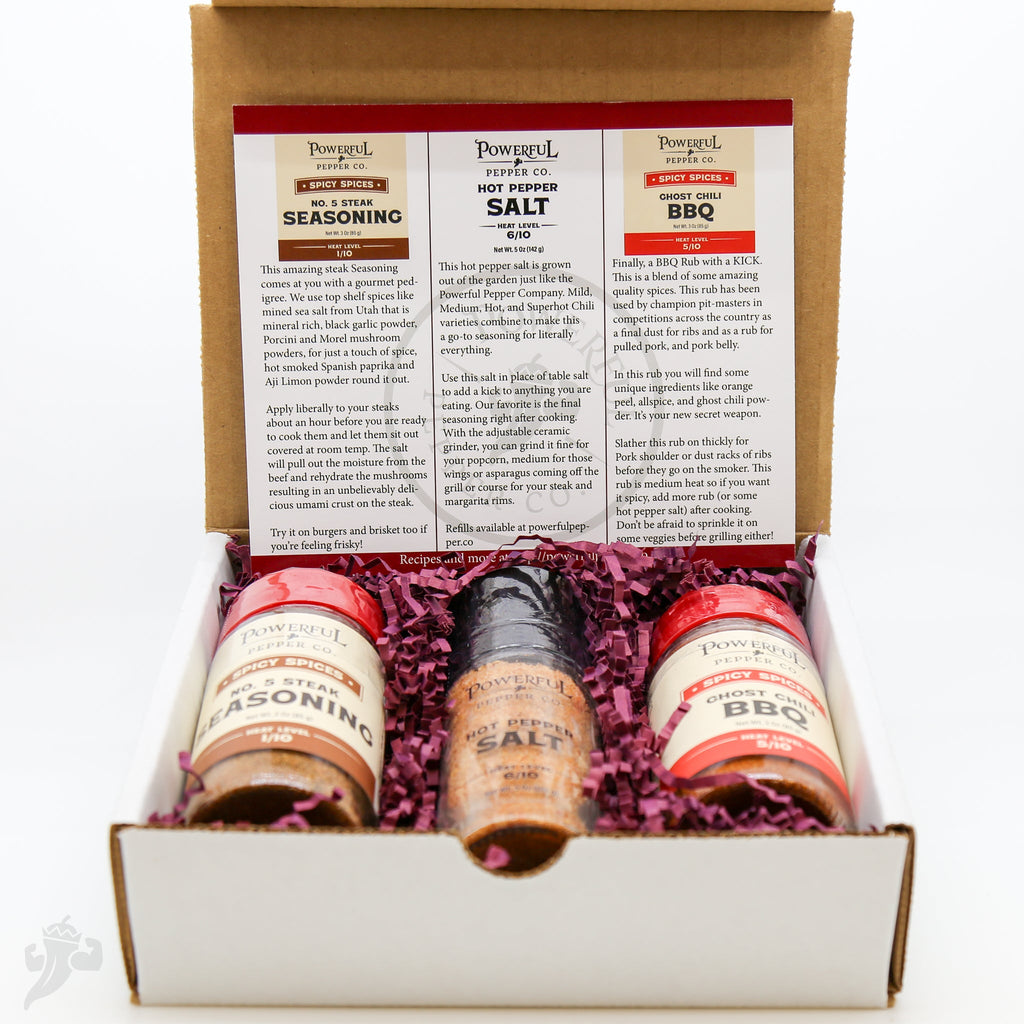 Open BBQ spice gift pack showing three labeled spice bottles and filler in tray