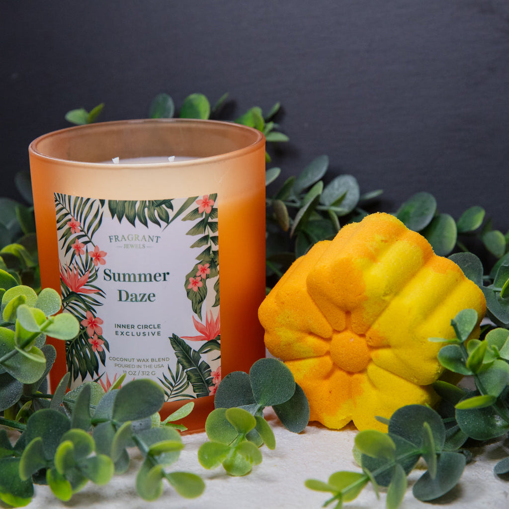 Orange glass candle beside yellow flower-shaped bath bomb
