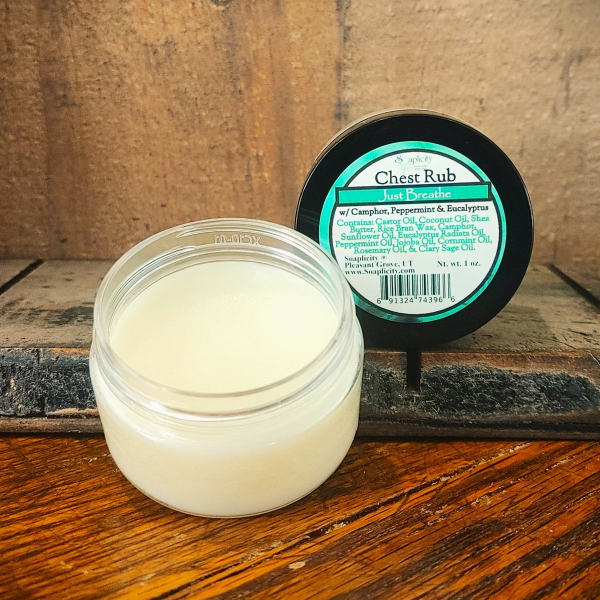 Chest rub balm jar with black-lidded container behind, white cream and label