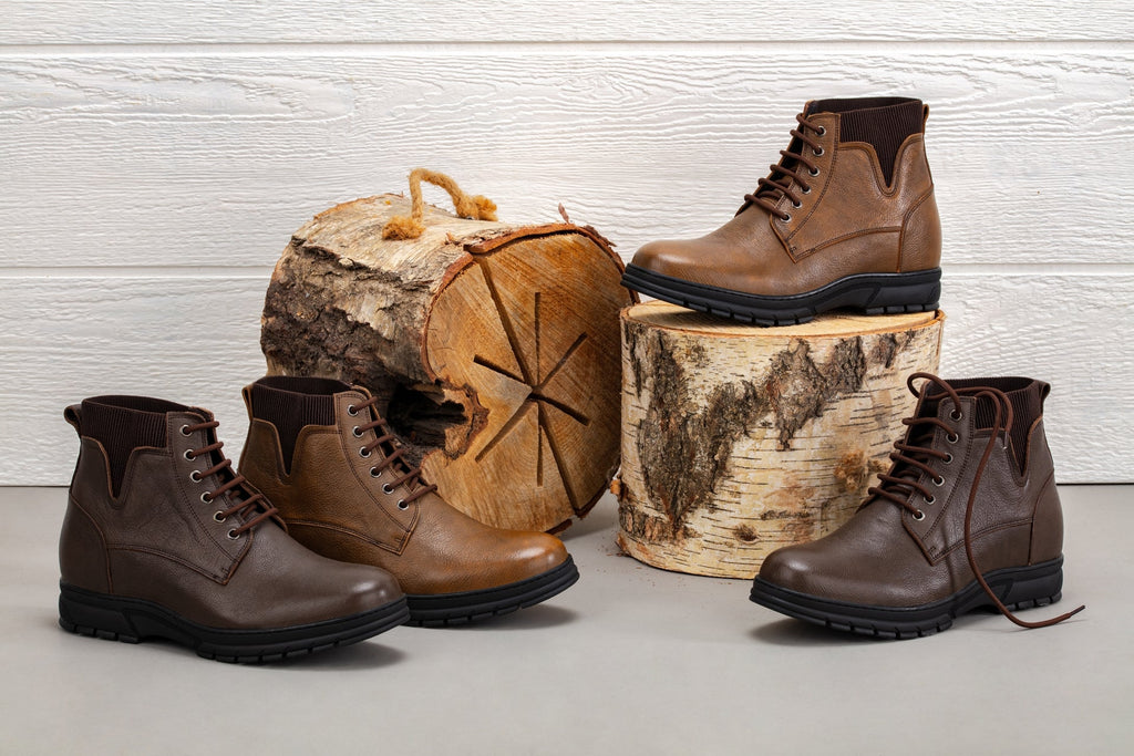 Chocolate brown lace-up work boots arranged on wooden log pieces with rugged soles